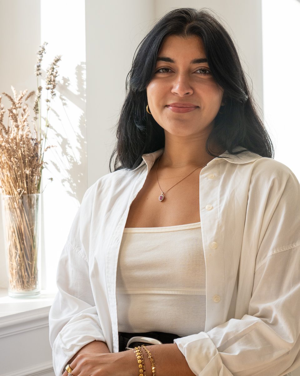 Portrait of a woman in a white shirt by a sunlit window